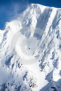 Vertical shot of a ski mountain with a daredevil skier photo