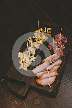 Vertical shot of sliced cheese and baloney on a wooden board