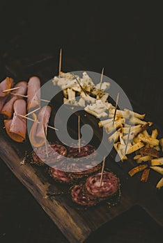 Vertical shot of sliced cheese and baloney on a wooden board