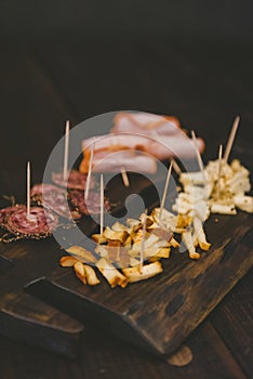 Vertical shot of sliced cheese and baloney on a wooden tray