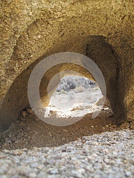 Vertical shot of a small cave oppening on slope of death valley mountains in California USA