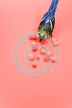 Vertical shot of a handmade bird figure with colorful cotton balls isolated on a red background