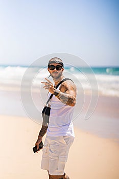 Vertical shot of the Spanish, young man with tattoos at the beach