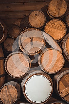 Vertical shot of stack of old wine barrels in the wooden basement