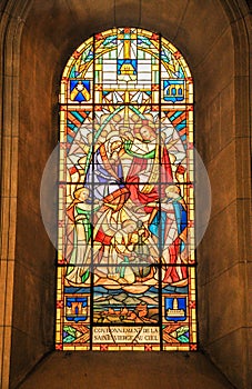 Vertical shot of a stained glass window of the Coronation of the Virgin church