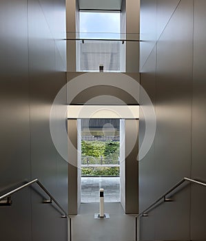 Vertical shot of the stairs of a modern building leading to the door