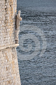 Vertical shot of the statue of Saint Blaise under the turret of city walls of Dubrovnik, Croatia