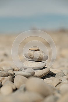 Vertical shot of stocked pebble stones on the beach on a sunny day