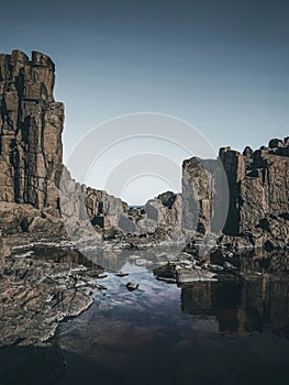 Vertical shot of stone formations near a stream in Kiama, Australia