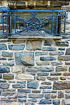 Vertical shot of stone wall texture with blue wrought iron grates