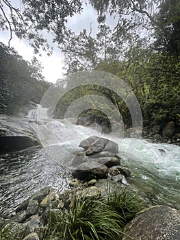 Vertical shot of a stream of a waterfall pounding into the rocks in North Queensland, Australia