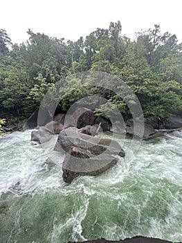 Vertical shot of a stream of a waterfall pounding into the rocks in North Queensland, Australia