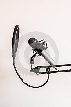 Vertical shot of studio microphone with pop filter isolated on white background