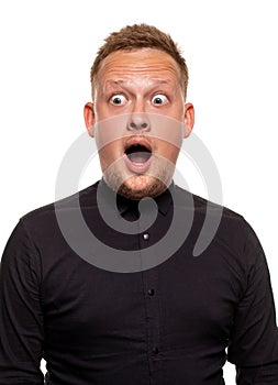 Vertical shot of stupefied stunned shocked young male keeps mouth widely opened, being surprised and very emotional