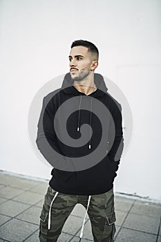 Vertical shot of a stylish attractive young man wearing a black hoodie