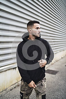 Vertical shot of a stylish attractive young man wearing a black hoodie
