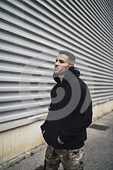 Vertical shot of a stylish attractive young man wearing a black hoodie