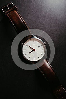 Vertical shot of a stylish wrist watch on dark background