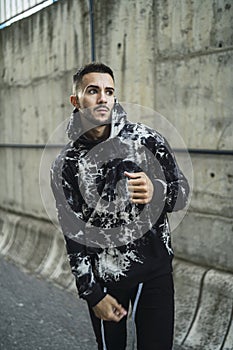 Vertical shot of a stylish young man wearing a hoodie