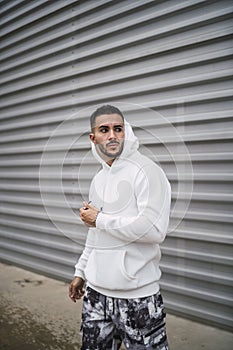 Vertical shot of a stylish young man wearing a white hoodie