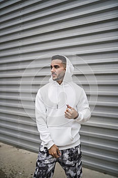 Vertical shot of a stylish young man wearing a white hoodie