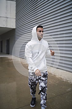 Vertical shot of a stylish young man wearing a white hoodie