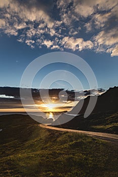 Vertical shot of a sunrise over a road in the middle of mountains in Lofoten, Norway