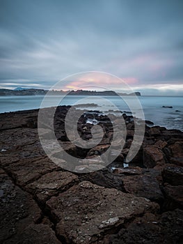 Vertical shot of a sunset landscape at Los Caballos beach in Miengo, Cantabria photo