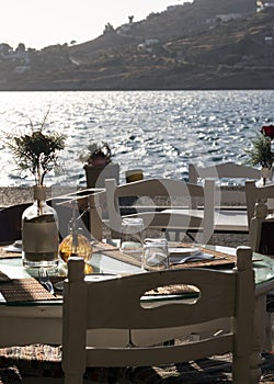 Vertical shot of tables and chairs at a Greek taverna on the island of Ios.