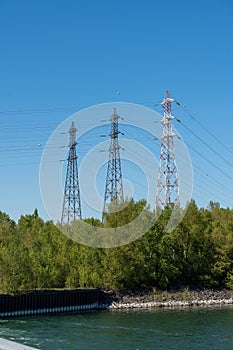 Vertical shot of three electricity pylons found in the countryside