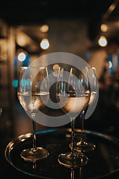 Vertical shot of three glasses of wine on a tray, in a restaurant