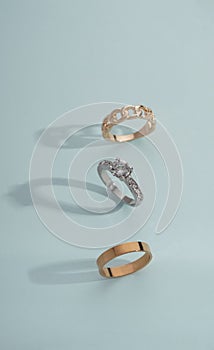 Vertical shot of three golden rings on boue background