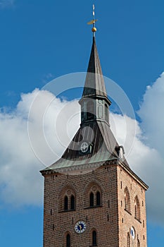 Vertical shot of the tower of Roman Catholic bishopric of Odense against blue sky, Denmark