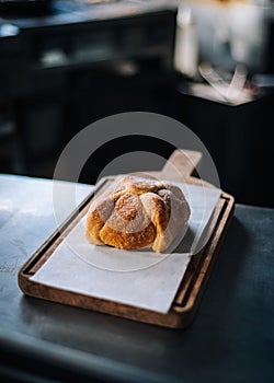 Vertical shot of the traditional Mexican Pan de muerto on a wooden board