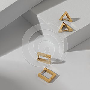 Vertical shot of two modern geometric earrings pairs on white background
