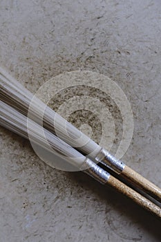Vertical shot of two painting brushes on a wooden surface - perfect for a creative background