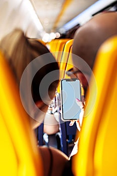 Vertical shot of two passengers in an airplane using their mobile phones while in flight