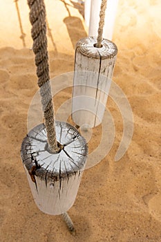 Vertical shot of two sawed tree stumps on a rope