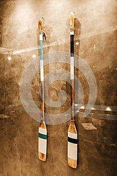 Vertical shot of two wooden oars hanging on a wall