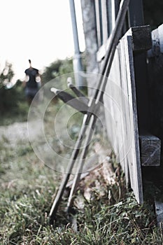 Vertical shot of two wooden sticks next to a fence in the garden