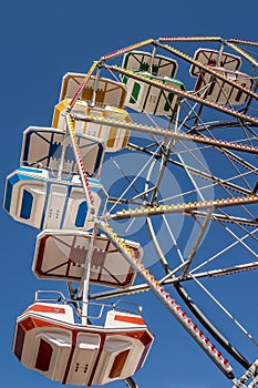 Vertical shot of a vibrant Ferris wheel against a vivid blue sky in summer