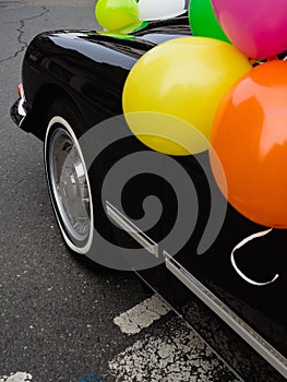 Vertical shot of a vintage car with balloons