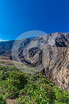 vertical shot of volcanic landscape with rocky and arid mountains in Volcan Poas National Park in Alajuela province of Costa Rica