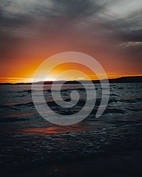 Vertical shot of waves against the shore of Lake Superior in Ontario, Canada at sunset