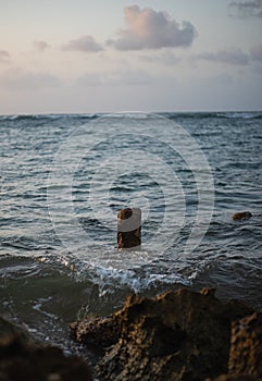 Vertical shot of waves washing the rocks on the coastline