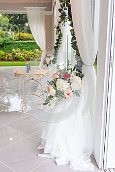 Vertical shot of a wedding venue with white curtains and beautiful flowers