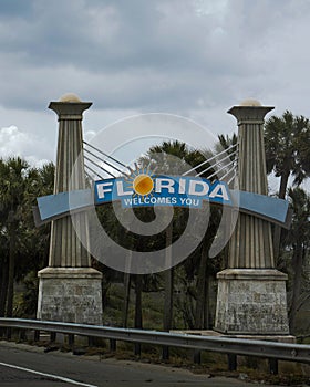Vertical shot of the Welcome to Florida Sign on Tourist attraction in Florida under a gray sky