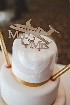 Vertical shot of a white cake with a plane and Mr and Mrs text