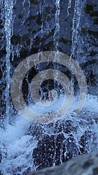 Vertical shot of white water gushing over the weir