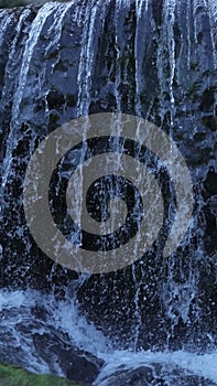 Vertical shot of white water gushing over the weir